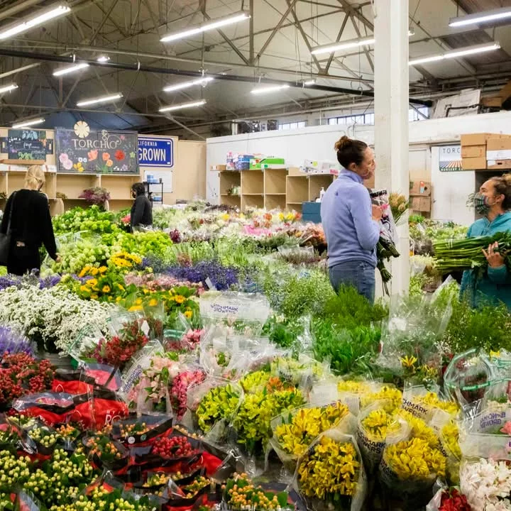 Vibrant display of various flower bouquets and market scenes.